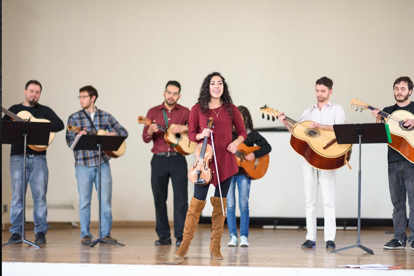 Mariachi ensemble rehearsing on a white stage